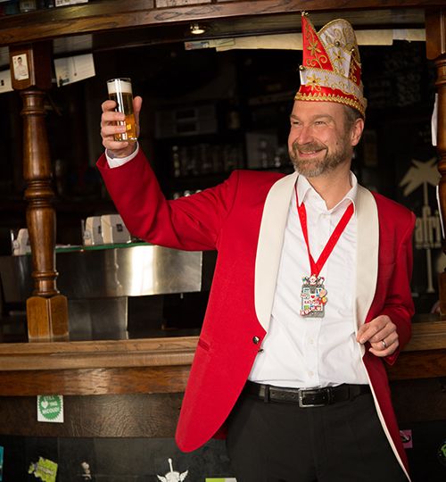 Volker Weininger als Der Sitzungspräsident mit Glas in der Hand